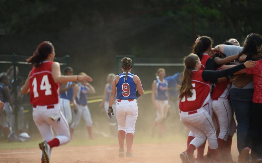 Kaiserslautern celebrates and Ramstein's Jasmine Morrison walks off after her grounder forced an out in the Royals' 10-5 loss to the Raiders in pool play Friday at the DODDS-Europe softball tournament.