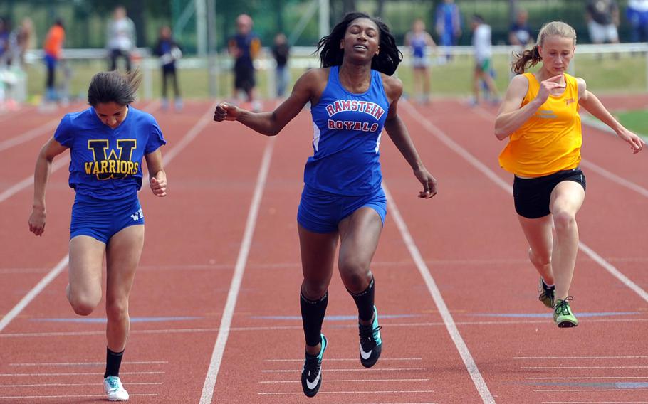 Ramstein's Denee Lawrence, center, crosses the finish line in 12.40 seconds to win the girls 100-meter dash at the DODDS-Europe track and field championships in Kaiserslautern, Germany, Saturday, May 23, 2015. At left is  runner-up Amelya Hempstead, at right is Frankfurt International's Maira Gauges who finished sixth.