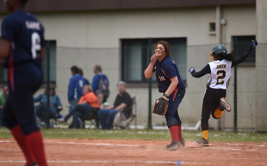 Aviano sophomore McKenzie Milligan stifles a chuckle as one of her teammates slips in the dirt trying to recover a ground ball in the infield during the Saints' 8-3 victory over Alconbury for the DODDS-Europe Division II/III softball title.
