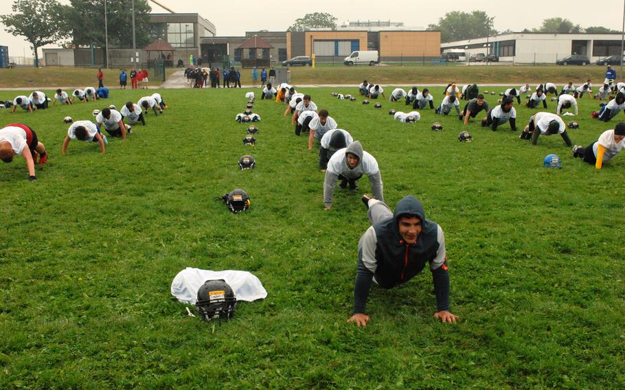 Lines of campers perform pushups  at the European Football Camp on Monday, Aug. 17, 2015 at Ansbach High School on Katterbach Kaserne in Ansbach, Germany. 