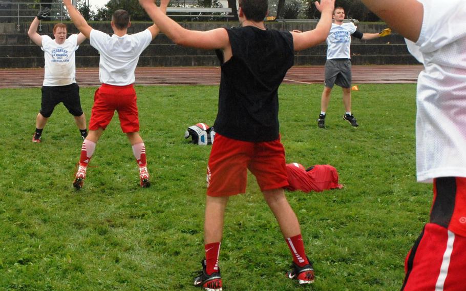 Kaiserslautern's Landon Weddle (facing) leads teammates through jumping jacks  at the European Football Camp on Monday, Aug. 17, 2015 at Ansbach High School on Katterbach Kaserne in Ansbach, Germany. 
