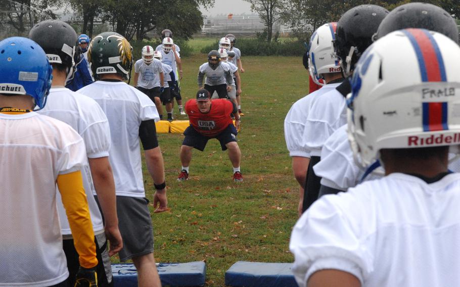 USA Football official Chad Hester demonstrates proper form during a drill at the European Football Camp on Monday, Aug. 17, 2015 at Ansbach High School on Katterbach Kaserne in Ansbach, Germany. The annual camp hosted over 300 football players from American high schools and European programs. Hester travelled to Ansbach from Texas to teach USA Football's "Heads Up" techniques for safe hitting and tackling. 