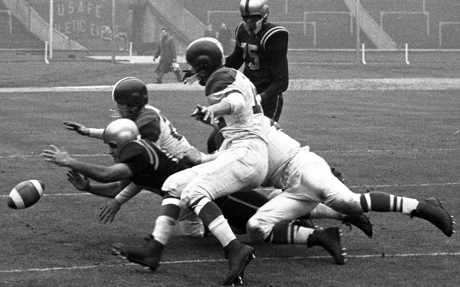 Danny Fuller of the London Rockets (at left, in dark jersey) and three Wiesbaden Flyers players dive for a loose ball during the United States Air Forces in Europe football championship game at London's famed Wembley Stadium in 1956. London won its third straight USAFE title, 32-7. 