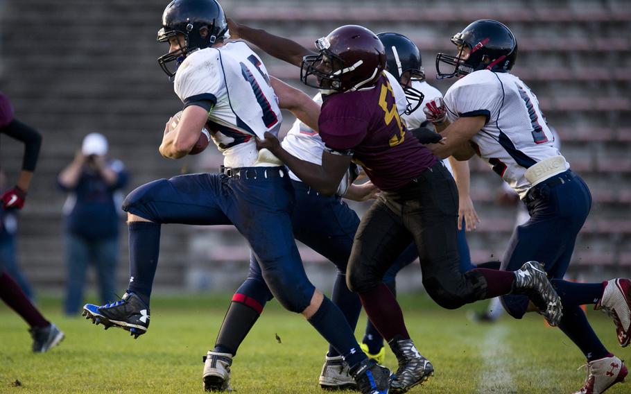 Bitburg's John Blake tries to break a tackle by Baumholder's Anthony Amos in Baumholder, Germany, Sept. 25, 2015. Blake went on to score a touchdown in the next play, and his own two-point conversion.