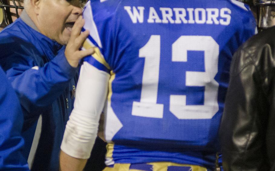 Wiesbaden head football coach Steve Jewell gives instructions to senior quarterback Eric Arnold prior to a crucial fourth-quarter drive during a game against Stuttgart on Friday, Oct. 23, 2015 in Wiesbaden, Germany. In addition to stellar defensive play, Arnold ran for one touchdown and threw another to fellow senior Carlos Ortiz in his team's 14-10 victory.