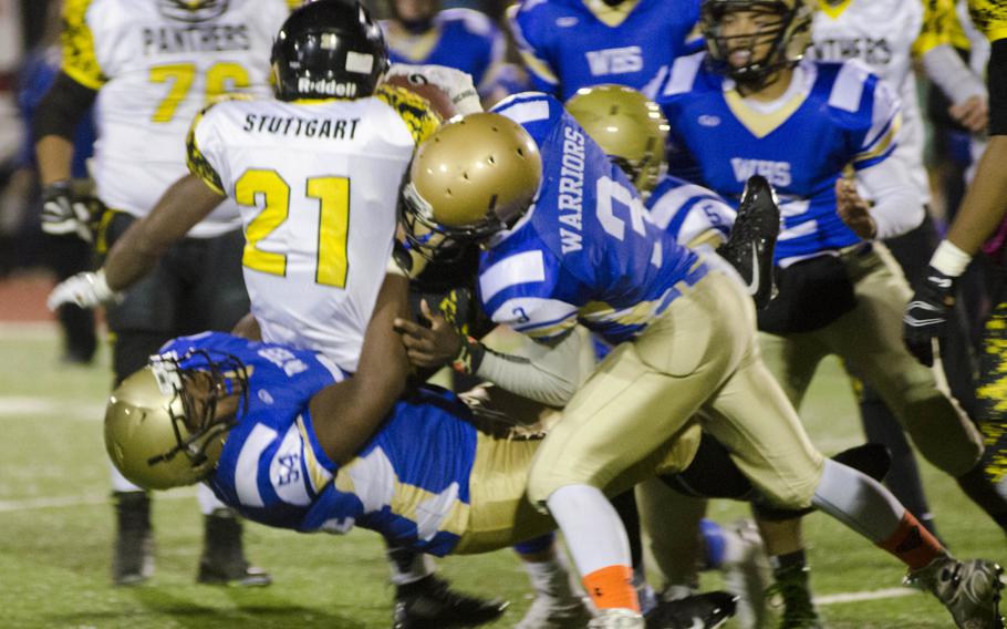 Stuttgart  running back Myles Bryant is tackled by a raft of Wiesbaden defenders during a regular-season game between the two schools Friday, Oct. 23, 2015 in Wiesbaden, Germany. Wiesbaden triumphed 14-10 on the back of a fourth-quarter touchdown pass from Eric Arnold to receiver Carlos Ortiz, ensuring a playoff appearance next week.