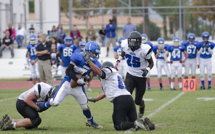 Rota's Luis Fuertes struggles with Hohenfels' Andrew Chavez, right, and Michael Rhoades during a Division II semifinal game on Saturday, Oct. 31, 2015. Rota won the game against Hohenfels 42-6.