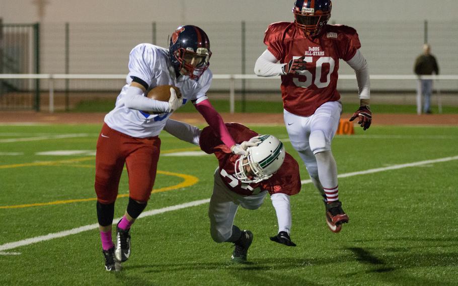 Riley Palmer stiff arms Elijah Stacks during the 2015 DODDS-Europe football all-star game held in Kaiserslautern, Germany, Nov. 14, 2015. Palmer's Team Honor came up short in the contest, losing to Team Glory, 20-14. 