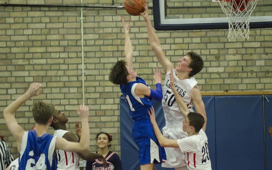 Lakenheath Jacob Croft blocks a shot from Brussels' Tim Wilkinson during a game at RAF Lakenheath, England, on Friday, Jan. 22, 2016. Lakenheath won the game 30