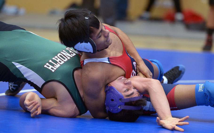 Bit burg's Kurt Nacionales puts the pressure on AFNORTH's Blake Borders in a 126-pound match in opening-day action at the DODDS-Europe wrestling championships in Wiesbaden, Germany, Friday, Feb. 19, 2016. Nacionales won.
