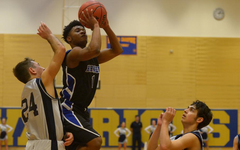 Hohenfels' Marshall Eddie goes up for a shot against Bitburg defenders Alexander Rodriguez, left, and Trey Bowles  in opening-day Division II action at the DODDS-Europe basketball championships in Wiesbaden, Germany, Wednesday, Feb. 24, 2016.Hohenfels won 48-32.
