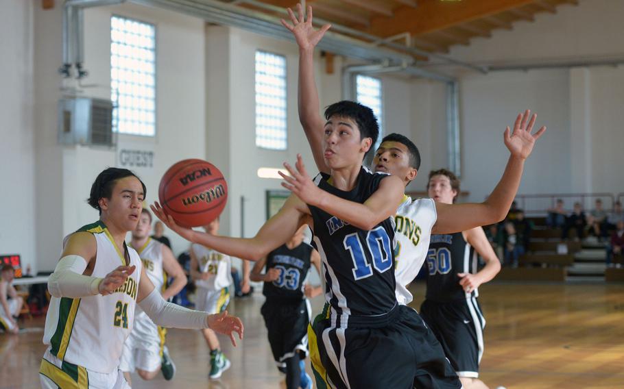 Incirlik's Noel Vasquez goes to the basket after getting past Alconbury's Anthony Stewart in a Division III game at the DODDS-Europe basketball championships in Wackernheim, Germany, Wednesday, Feb. 24, 2016. Incirlik won 52-47. At left is Alconbury's Fritz Sherenco.