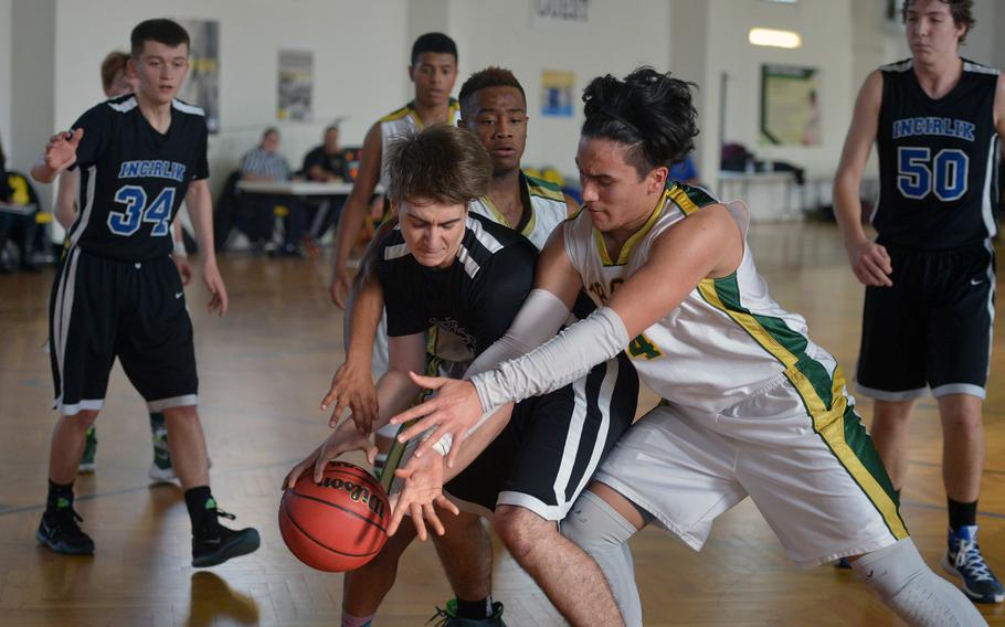 Incirlik's Mark Anarumo fights for the ball with Alconbury's Fritz Serenco while Serenco's teammate Adarious Gallon stands by to assist. Incirlik beat Alconbury 52-47  in a Division III game at the DODDS-Europe basketball championships in Wackernheim, Germany, Wednesday, Feb. 24, 2016.
