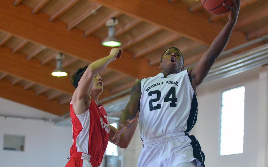 Bahrain's Rashay Douglas takes it to the hoop against AOSR's Matia Gheradini in a Division II game at the DODDS-Europe basketball championships in Wackernheim, Germany. Bahrain won the game 48-9.
