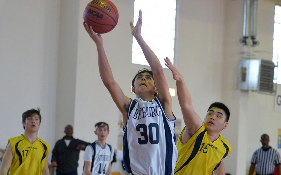 Bitburg's Trey Bowles goes to the basket against Florence's Lorenzo Zheng in a Division II game at the DODDS-Europe basketball championships in Wackernheim, Germany. Bitburg won 44-4. 