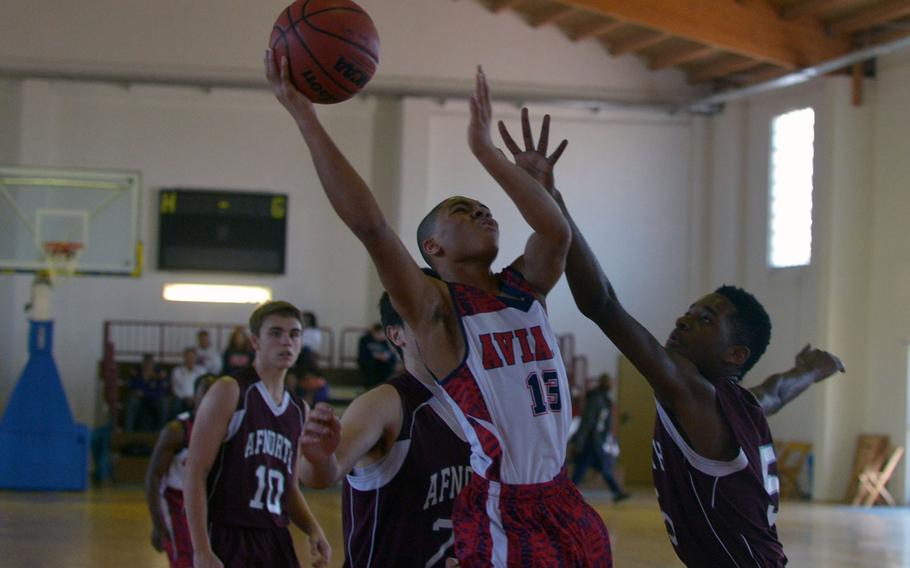 Aviano's Jimmie Montgomery goes in for a shot against AFNORTH's Malik Mayes  in a Division II game at the DODDS-Europe basketball championships in Wackernheim, Germany. Aviano won the game 53-34.
