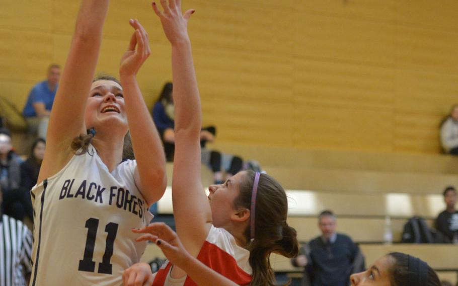 Black Forest Academy's Katie Greathouse, left, shoots as American Overseas School of Rome's Cristina D'Alessio tries to defend in a girls Division II semifinal at the DODDS-Europe basketball championships in Wiesbaden, Germany, Friday, Feb. 26, 2016. BFA won 50-17 to advance to Saturday's final against Bitburg, a rematch of last year's title game. At right is AOSR's Henna Moussavi.