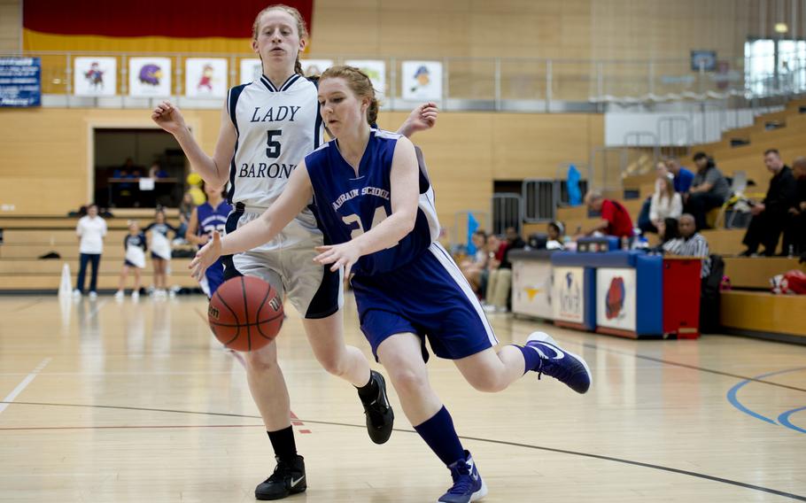 Bahrain's Olivia Johnson dribbles around Bitburg's Baileigh McFall during a DODDS-Europe Division II semifinal game at Clay Kaserne, Germany, Friday, Feb. 26, 2016. Bitburg won 42-16.