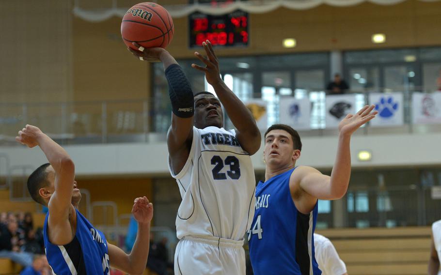 Hohenfels' Jordan Kelly gets past Rota's Jashaun Garrison, left, and Andrew Drake  in a Division II semifinal at the DODDS-Europe basketball championships in WIesbaden, Germany. Friday, Feb. 26, 2016. Rota defeated Hohenfels 54-36 to advance to Saturday's final against Black Forest Academy.