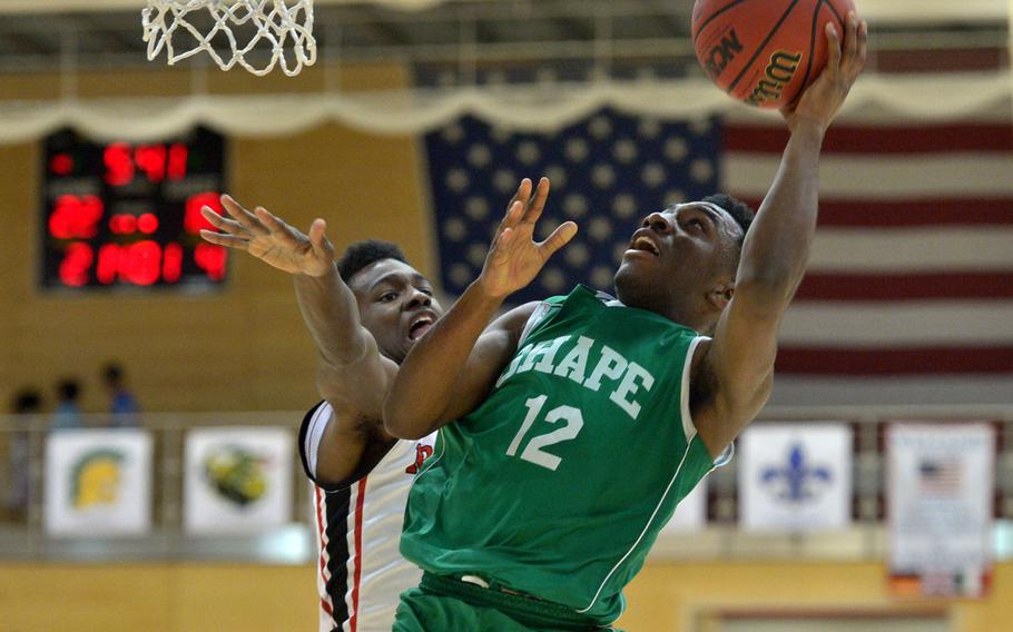 SHAPE's Cameron Little goes to the hoop against Kaiserslautern's Terrell Robbins in a Division I semifinal at the DODDS-Europe basketball championships in WIesbaden, Germany. Friday, Feb. 26, 2016. Kaiserslautern beat SHAPE 42-27 to advance to Saturday's final against Ramstein.