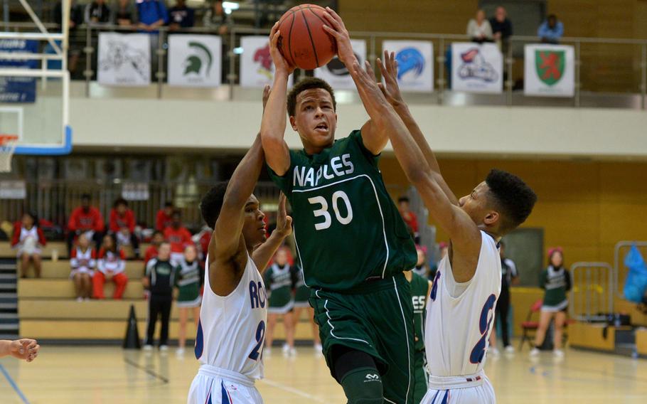 Naples' Karrington Evans aims for the basket despite the Ramstein defense of Brendan Hicks, left, and Kendell Allen.  in a Division I semifinal at the DODDS-Europe basketball championships in WIesbaden, Germany. Friday, Feb. 26, 2016. Ramstein won 60-41 to advance to Saturday's final against Kaiserslautern.
