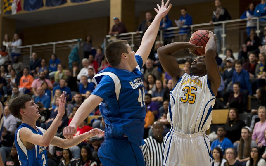 Ansbach's Sam Sasser shoots over Brussels' Callum Proulx, center, and Tim Wilkinson during the DODDS-Europe Division III championship game in Wiesbaden, Germany, Saturday, Feb. 27, 2016. Ansbach lost 41-38. 