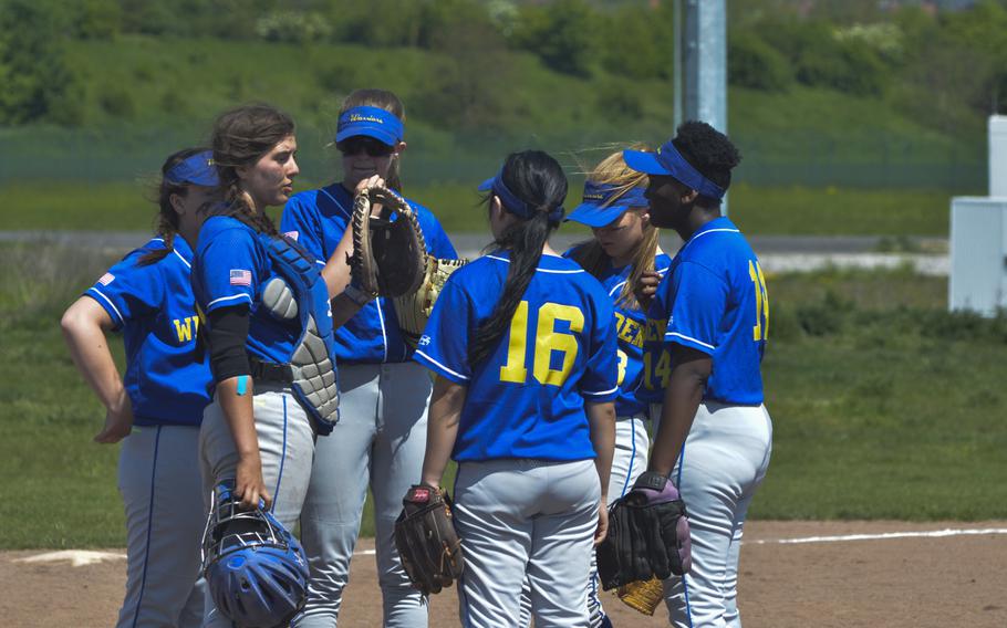 Wiesbaden captain Olivia Stecker, second from left, leads a team meeting during a doubleheader between the Royals and Warriors at Wiesbaden, May 7, 2016. Defending Division I champ Ramstein won both games by double digits.