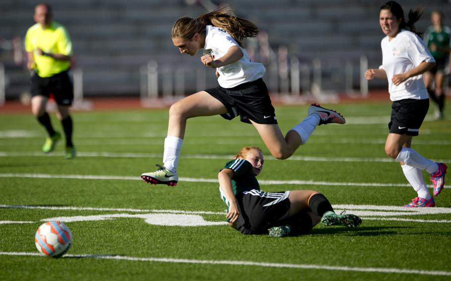 Stuttgart's Emily Smith, center, jumps over Naples' Katherine Abresch during the DODEA-Europe soccer championship in Kaiserslautern, Germany, on Saturday, May 21, 2016. Stuttgart won the Division I game 4-0.