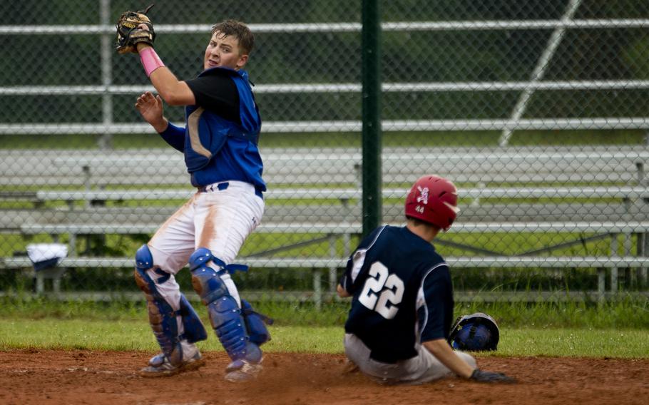 Bitburg's Nicholas Orlando, right, slides in to home before a tag by Sigonella's Carson Morrison during the DODEA-Europe baseball tournament in Kaiserslautern, Germany, on Friday, May 27, 2016. Bitburg won the game 8-6.
