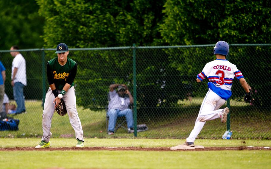 Ramstein's Stan Cruz gets to first base as SHAPE's Travis Disla protects himself from the ball during the DODEA-Europe baseball tournament at Ramstein Air Base, Germany, on Friday, May 27, 2016. Ramstein won the Division I game 7-6.