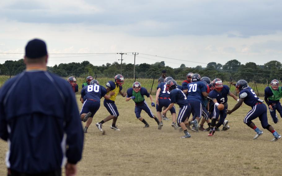 Lakenheath Lancer offensive coordinator Brian Rutleg runs players through plays during after-school practice at RAF Lakenheath, England, Wednesday, Aug. 31, 2016.