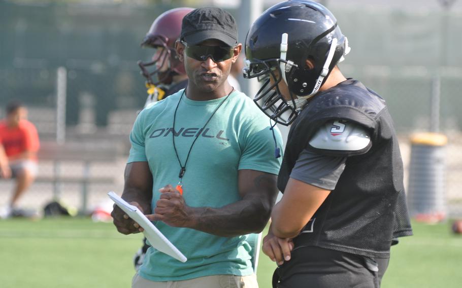 Vicenza assistant coach Corey Thomas talks to senior Yoonbeom Lee, an anchor on the offensive and defensive lines, during a practice Wednesday, Sept. 7, 2016 at Caserma Ederle in Italy.