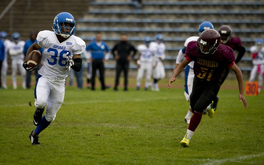 Rota's De'ontae Bradley, left, runs past Baumholder's Hunter Poole in Baumholder, Germany, on Saturday, Oct. 8, 2016. Rota won the game 45-0.