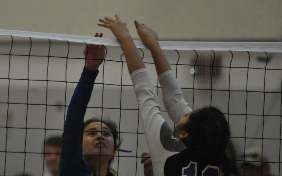 Sigonella's Kristiana Wyrick tips the ball over a block from Hohenfels' Alexus Garcia in Friday night volleyball action at Aviano Air Base, Italy.