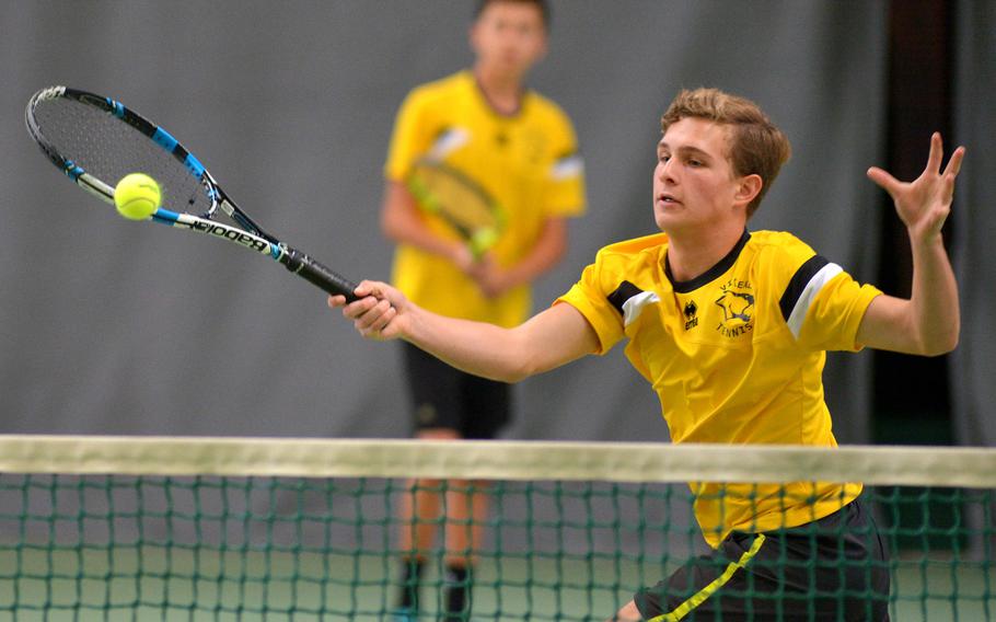 Vicenza's William Auchincloss returns a shot as teammate Connor Wilson watches, in their 6-0, 7-6 loss to Kaiserslautern's Deven Gerber and Tyler Barnes in a boys doubles match at the DODEA-Europe tennis championships in Wiesbaden, Germany, Thursday, Oct. 27, 2016. 