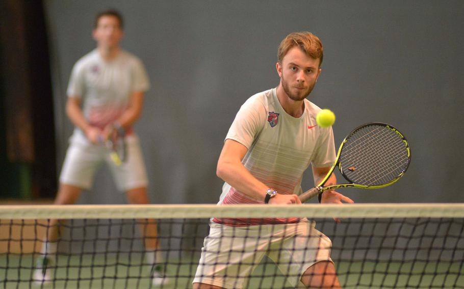 ISB's Arthur Francois-Poncet hits a ball at the net against Ramstein as teammate Gianluca Curti watches in a boys doubles semifinal at the DODEA-Europe tennis championships in Wiesbaden, Germany, Friday, Oct. 28, 2016. The ISB #2 team had to retire the match after Curti was injured.