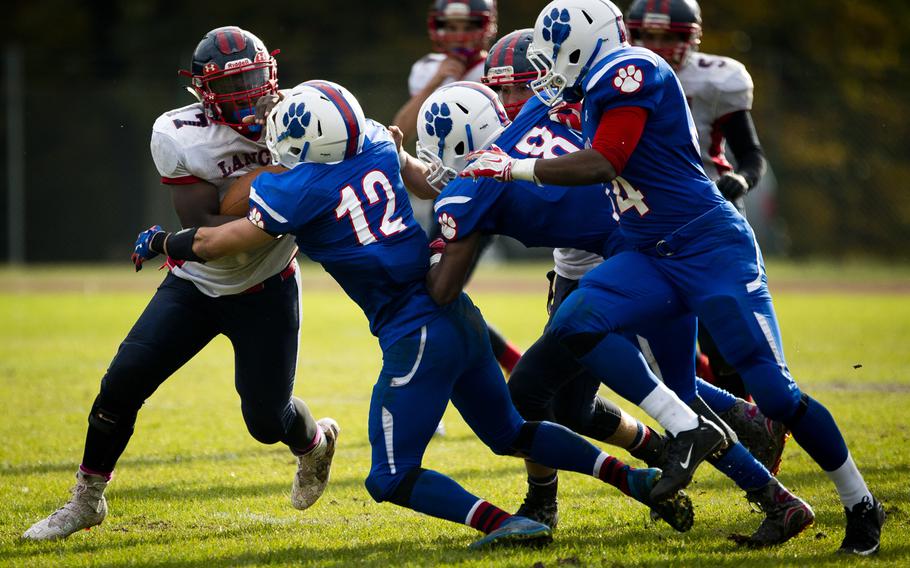 Lakenheath's Marcus Smith, left, tries to get through Ramstein's defense at Ramstein Air Base, Germany, on Saturday, Oct. 29, 2016. Lakenheath lost the DODEA-Europe Division I semifinal game against Ramstein 58-15.