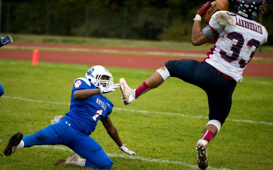 Lakenheath's Christopher Cruz catches a pass over Ramstein's Jaylen Bussey during the DODEA-Europe Division I semifinal at Ramstein Air Base, Germany, on Saturday, Oct. 29, 2016. Lakenheath lost the game 58-15.