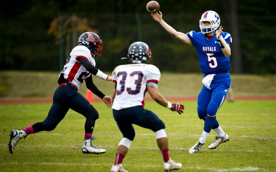 Ramstein's Trevor Miller throws a pass over Lakenheath defenders at Ramstein Air Base, Germany, on Saturday, Oct. 29, 2016. Ramstein won the game 58-15.