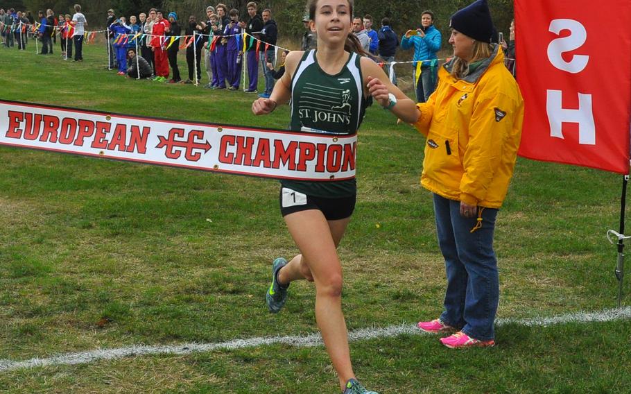 St. John's junior Kayla Smith breaks the finish tape in first place in the girls' race on Saturday at the 2016 DODEA European cross country championships at Baumholder, Germany. Smith broke her own record on the course, set one year ago, with a time of 18:45.21.