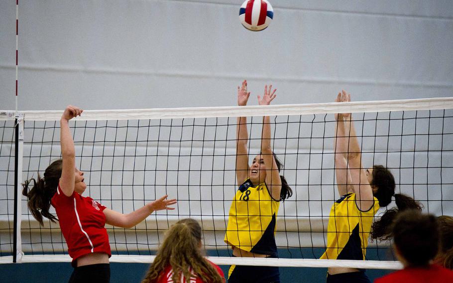 American Overseas School of Rome's Mailea Huber, left, hits the ball over Florence's defenders during a DODEA-Europe tournament match at Vogelweh, Germany, on Thursday, Nov. 3, 2016. AOSR lost two of its three sets against Florence 25-13, 12-25 and 25-23.