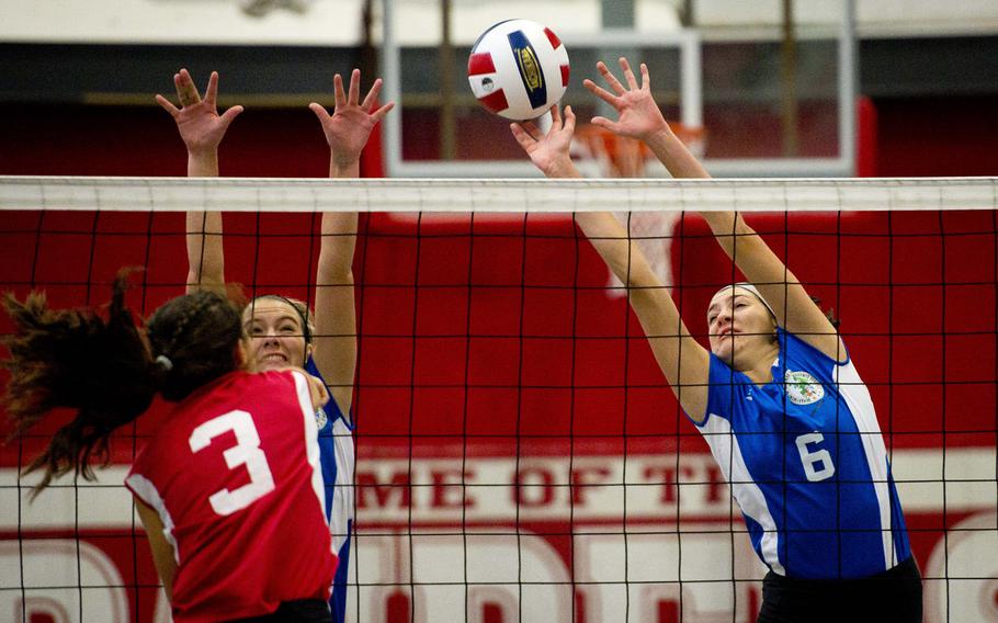 Black Forest Academy's Erin Fortune, right, and Wiesbaden's Mallory Johnson jump to block a shot by Sigonella's Korley Jones in Kaiserslautern, Germany, on Saturday, Nov. 12, 2016.