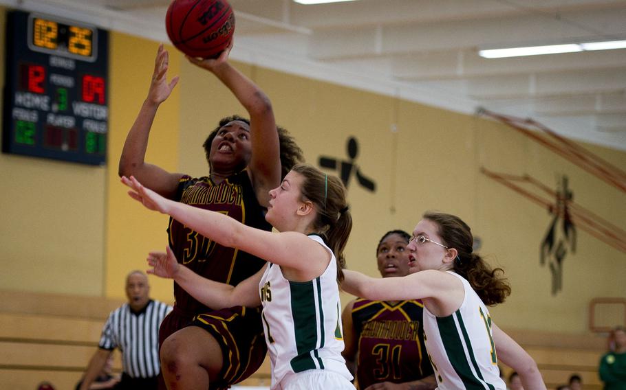 Baumholder's Tytianna Martinez goes up for a shot over Alconbury's Laela Evans, center, and Marianna Szukala in Baumholder, Germany, on Saturday, Dec. 10, 2016. Baumholder won the game 31-12.