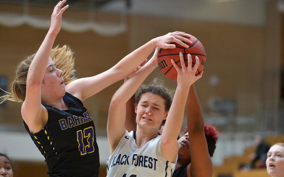 Black Forest Academy's Katie Greathouse pulls down a rebound against Bahrain's Zoie Howes, left, and Olivia Williams in a Division II semifinal at the DODEA-Europe basketball championships in Wiesbaden, Germany, Friday, Feb. 24, 2017. BFA beat Bahrain 50-16 to advance to Saturday's final against Bitburg.