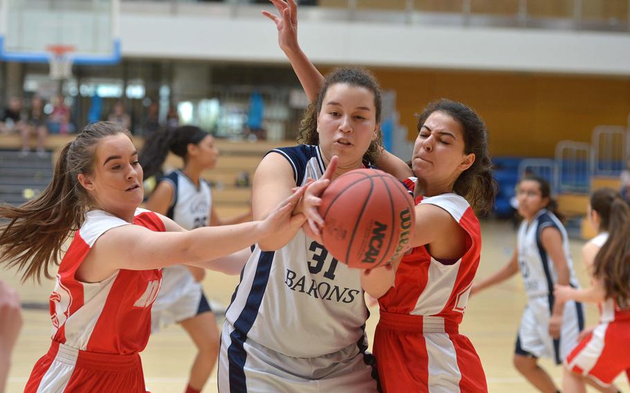 Bitburg's Elise Rasmussen grabs a loose ball pressured by AOSR's Mailea Huber, left, and Henna Moussavi in a Division II semifinal at the DODEA-Europe basketball championships in Wiesbaden, Germany, Friday, Feb. 24, 2017. Bitburg won the game 36-12 to advance to Saturday's final against Black Forest Academy.