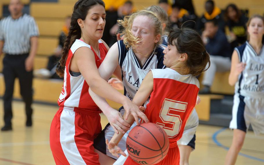 Bitburg's Baileigh McFall fights for the ball with AOSR's Alessia Rosu, left, and Anne Blanchette in a Division II semifinal at the DODEA-Europe basketball championships in Wiesbaden, Germany, Friday, Feb. 24, 2017. Bitburg won the game 36-12 to advance to Saturday's final against Black Forest Academy.