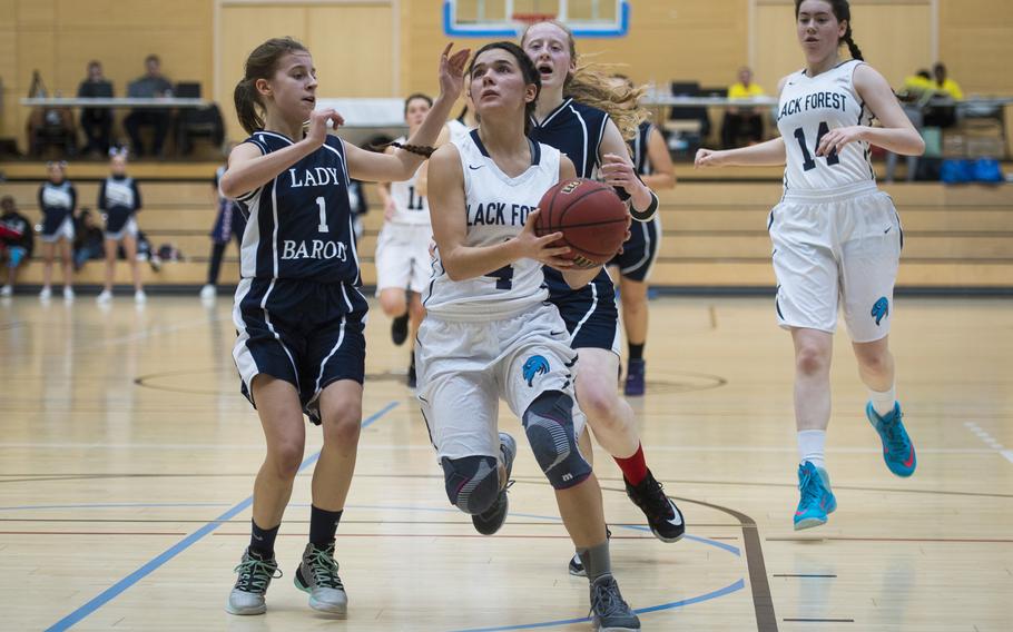 Black Forest Academy's Naomi Ruegg, right, heads for the hoop past Bitburg's Ava Bohn during the DODEA-Europe Division II championship in Wiesbaden, Germany, on Saturday, Feb. 25, 2017.