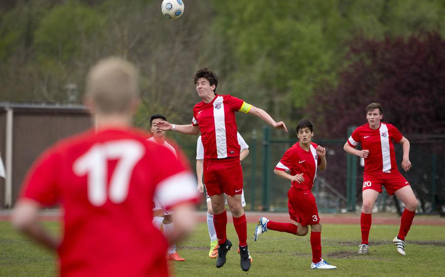 International School of Brussels' Ioan Bishop heads the the ball as teammates Dafydd Bishop, far right, and Vivan Lamot watch at Ramstein Air Base, Germany, on Friday, April 28, 2017. ISB lost the game to Ramstein 1-0.