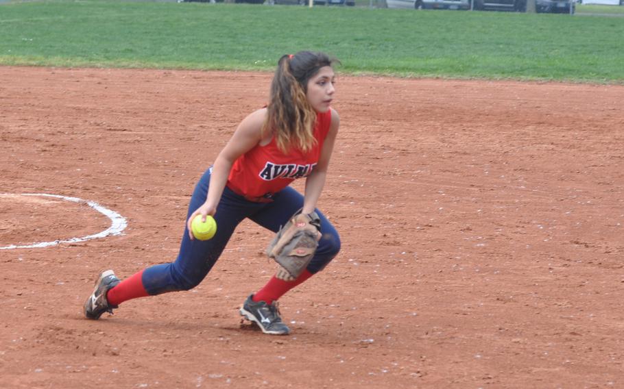 Aviano pitcher Amariah Morales tosses the ball toward first after fielding it cleanly Saturday in the Saints' 12-8 victory over Sigonella.