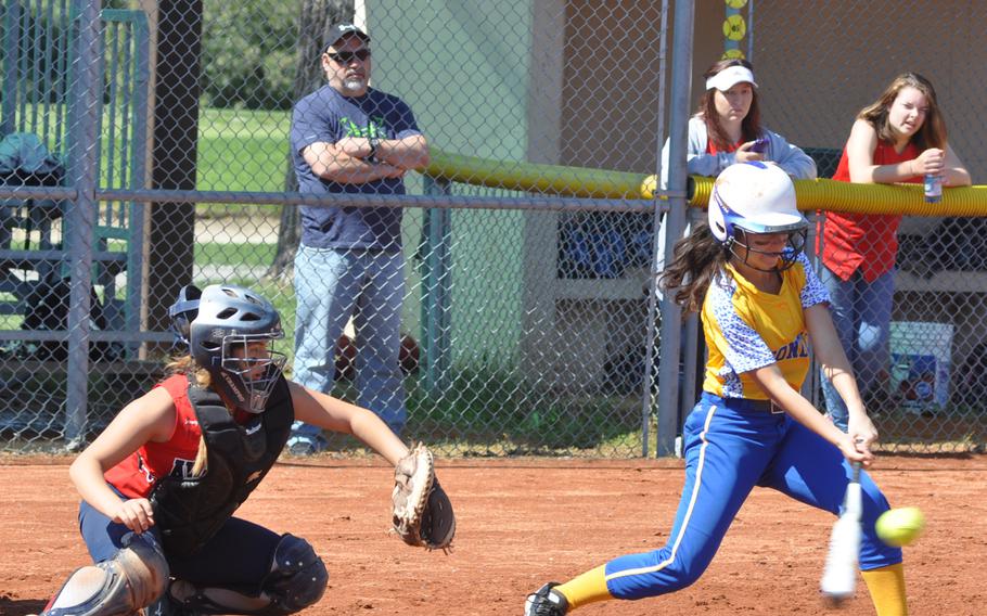 Sigonella's Lindsay Parker connects with a pitch before Aviano catcher Eliana Morales can grab it in the Saints' 6-4 victory Saturday.